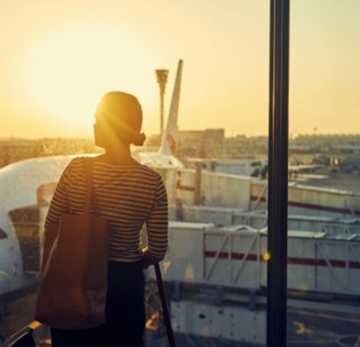 Businesswoman at airport looking at airport tarmac