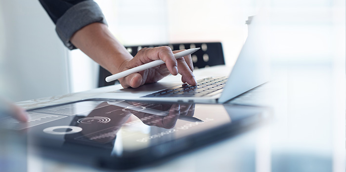 Businessman researching group air travel reporting on laptop